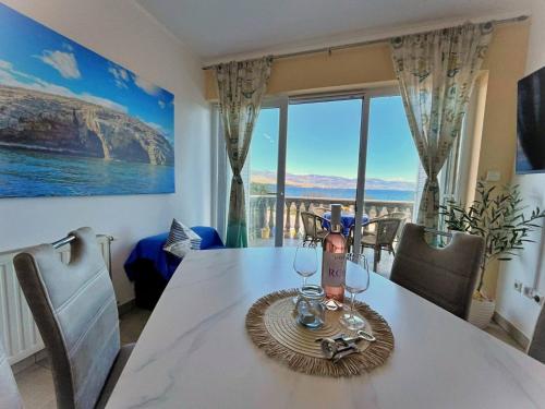 a dining room with a table with wine glasses on it at Apartments Neptun in Šilo