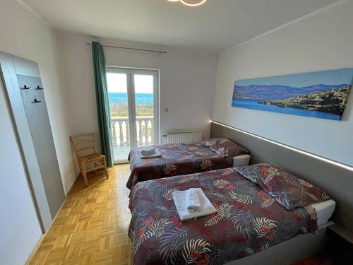 a small room with two beds and a window at Apartments Neptun in Šilo