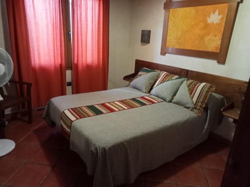 a bedroom with a bed and a red curtain at Livingtarifa Casa Ariza in Tarifa