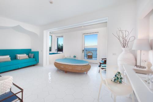 a living room with a blue couch and a table at Hotel Belair in Sorrento