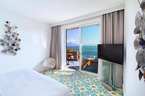 a bedroom with a bed and a view of the ocean at Hotel Belair in Sorrento