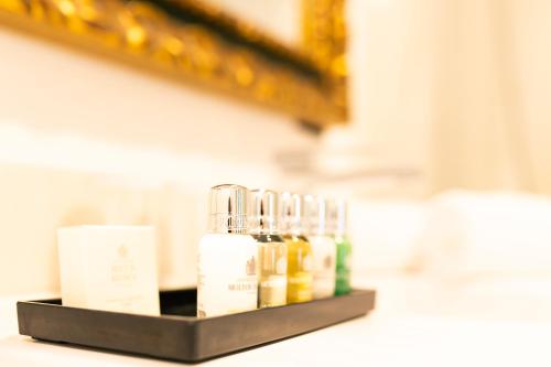 a shelf with several bottles of essential oils on it at Legado Alcazar Hotel in Seville