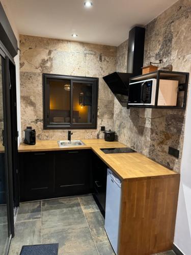 a kitchen with a sink and a microwave at Le studio Léva in La Plaine des Palmistes
