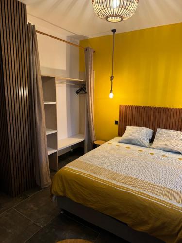 a bedroom with a bed with a yellow wall at Le studio Léva in La Plaine des Palmistes