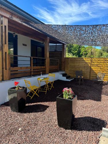 a patio with chairs and a table and a building at Le studio Léva in La Plaine des Palmistes