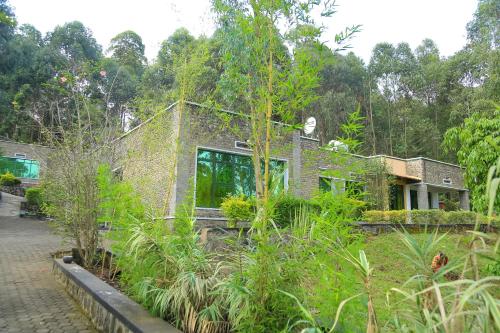 a brick house with plants in front of it at Karisimbi Cave Resort in Ruhengeri