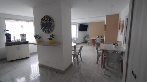 a living room with a clock on a wall at Casa Hotel Solare de la 70 in Medellín