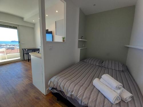 une chambre avec un lit avec deux serviettes blanches dessus dans l'établissement Chenonceau, à Cannes