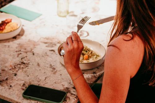 a woman holding a fork in front of a bowl of food at The Flint Hotel in Belfast