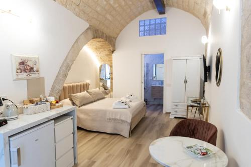 a living room with a bed and a table in a room at Carola Luxury Room in Bari