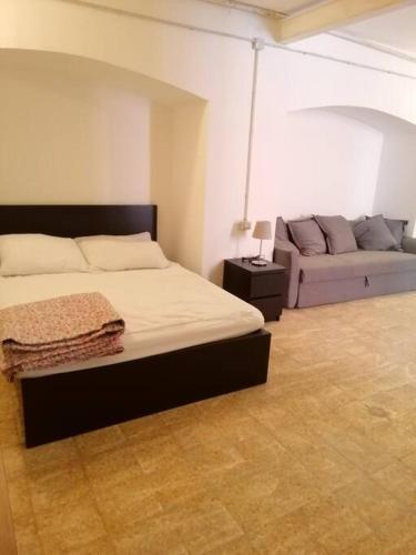a bedroom with a bed and a couch at Appartamento Teatro Duse in Bergamo