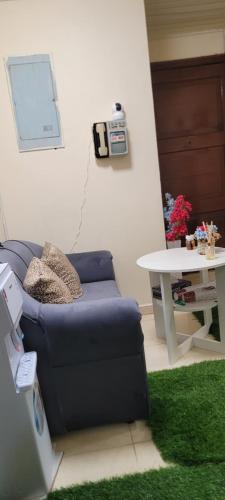 a living room with a blue couch and a table at MAMA DELiGHT HOME in Abu Dhabi