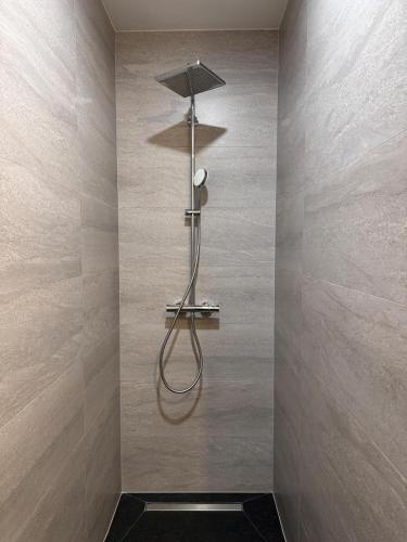 a shower in a bathroom with a wall at Harmony Peak Jahorina in Jahorina