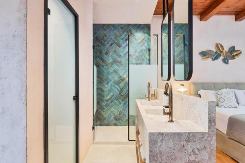 a bathroom with two sinks and a bedroom at Mansio Boutique Hotel in Rethymno Town