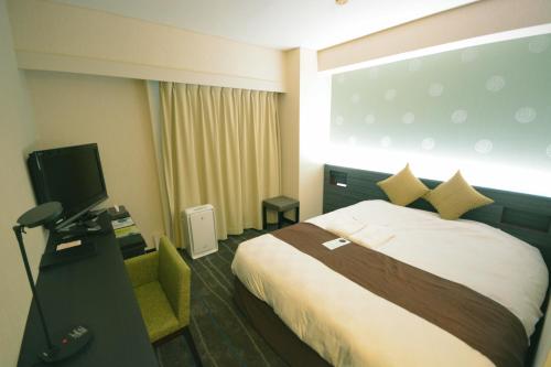 高松市にある高松東急REIホテルのベッド1台、薄型テレビが備わるホテルルームです。