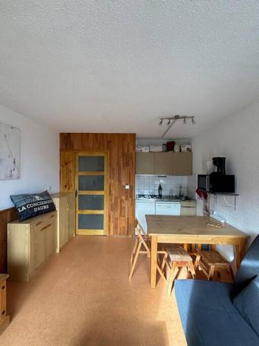 un salon avec une table et une cuisine dans l'établissement Beau 6 places à la résidence Cantoural, à Le Plan