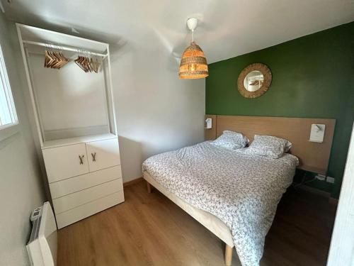 une petite chambre avec un lit et un miroir dans l'établissement Appartement au ski spacieux pour 7P, piscine sauna, à La Foux d'Allos