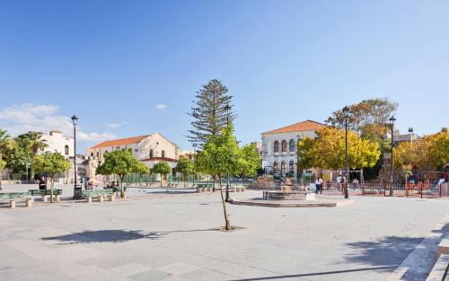 a tree in the middle of a plaza with buildings at Mansio Boutique Hotel in Rethymno Town