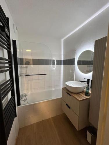 une salle de bain avec un lavabo, une baignoire et un miroir dans l'établissement Appartement au ski spacieux pour 7P, piscine sauna, à La Foux d'Allos