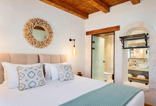 a bedroom with a bed with a mirror on the wall at Mansio Boutique Hotel in Rethymno Town