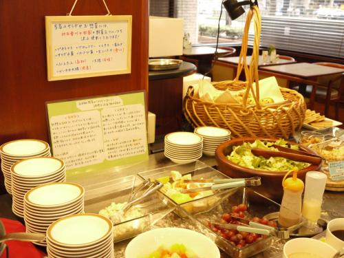 a buffet of food with plates and bowls of food at Takamatsu Tokyu REI Hotel in Takamatsu