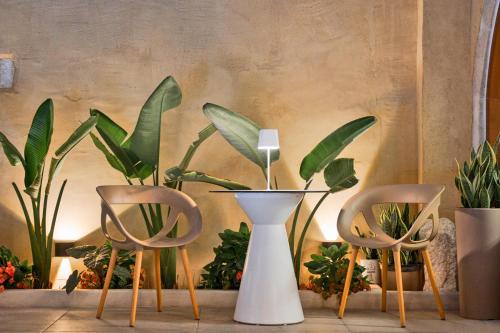 two chairs and a vase and some plants at Mansio Boutique Hotel in Rethymno Town