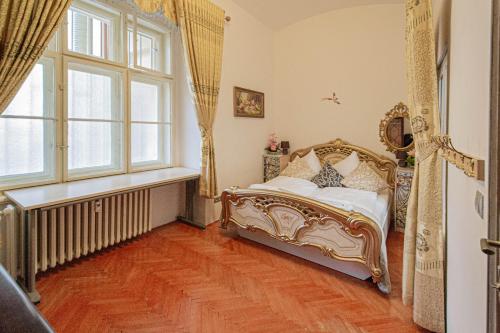 an ornate bed in a room with a window at The Grand Royal 3BDR Heart of Old Town in Prague