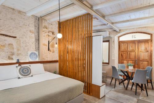a bedroom with a bed and a table and chairs at Mansio Boutique Hotel in Rethymno Town