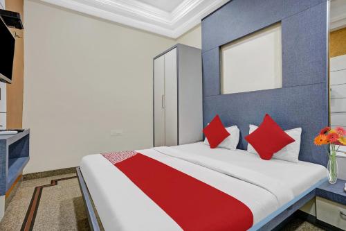 a bedroom with a large bed with red pillows at Hotel O Chhaya in Aurangabad