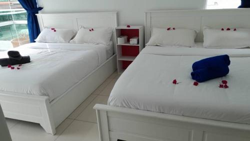 Un dormitorio con dos camas con flores rojas en ellas. en Rose Hill Gardens, en Brinchang