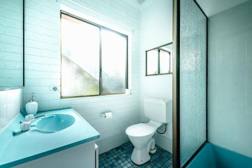 a bathroom with a toilet and a sink and a window at Bella Vista Bellingen in Bellingen