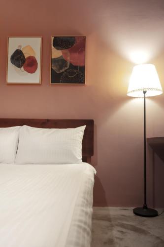 a bedroom with a white bed and a lamp at 島隅慢旅 in Xiaoliuqiu