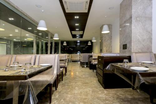 une salle à manger avec des tables et des chaises dans un restaurant dans l'établissement Varju Villa, à Udaipur