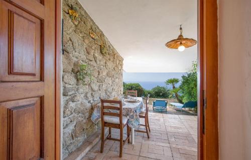 a dining room with a table and chairs and a stone wall at 1 Bedroom Cozy Home In Joppolo in Ioppolo