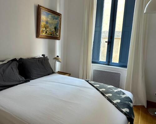 une chambre avec un grand lit avec une fenêtre dans l'établissement La Suite de la Cathédrale, à Narbonne