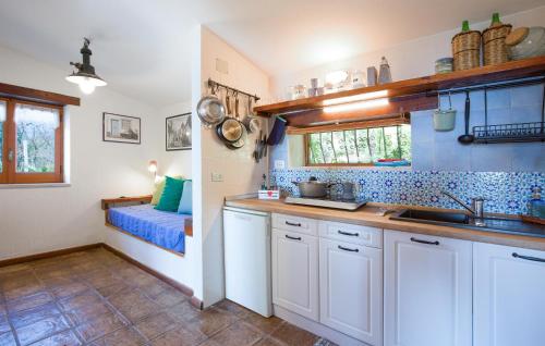 a kitchen with white cabinets and blue tiles at 1 Bedroom Cozy Home In Joppolo in Ioppolo