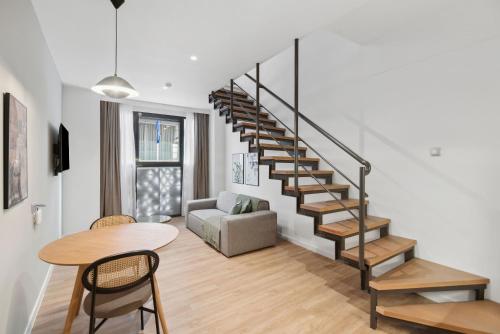a living room with a spiral staircase and a table at Limehome Piraeus Olive in Piraeus