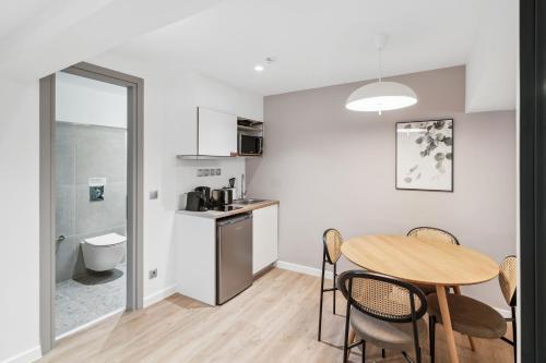 a kitchen and dining room with a table and chairs at Limehome Piraeus Olive in Piraeus