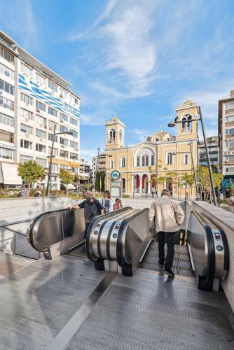 a group of people walking down escalators in a city at Limehome Piraeus Olive in Piraeus