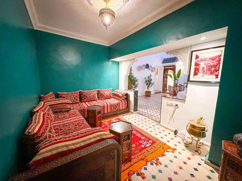 a bedroom with a bed in a room with green walls at Riad M Azbetz in Marrakech