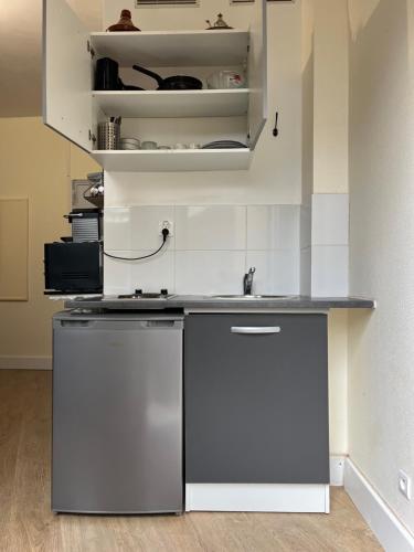 une cuisine avec un évier et un réfrigérateur dans l'établissement Charmant studio spacieux paris, à Paris