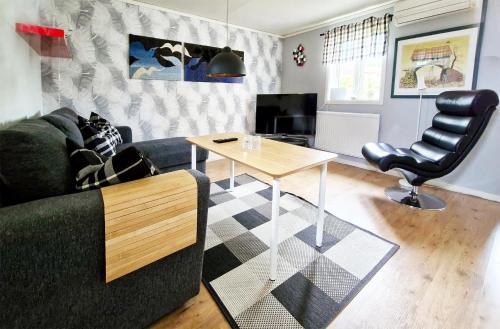 a living room with a couch and a table at 1A, Stuga med 50m till strand in Byxelkrok
