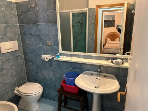 a bathroom with a sink and a toilet and a mirror at appartamento trilocale dolores in Campo nell'Elba