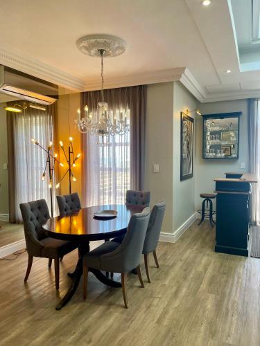 a dining room with a table and chairs at Romney Park Luxury Apartments by The Stay Collection in Cape Town