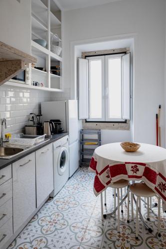 a kitchen with a table and a washing machine at Angels Homes n.27 1ºandar, Bairro tipico, Centro cidade in Lisbon