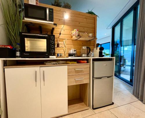 a kitchen with a counter with a microwave and a refrigerator at B&B Wellness Soest in Soest