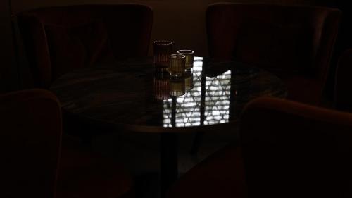 a table in a dark room with two glasses on it at Hotel Lepelbed in Ghent