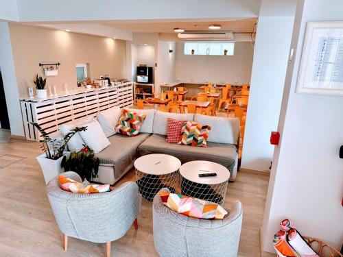 een woonkamer met een bank, stoelen en tafels bij Boutique Hotel - O House Ericeira Hills in Ericeira