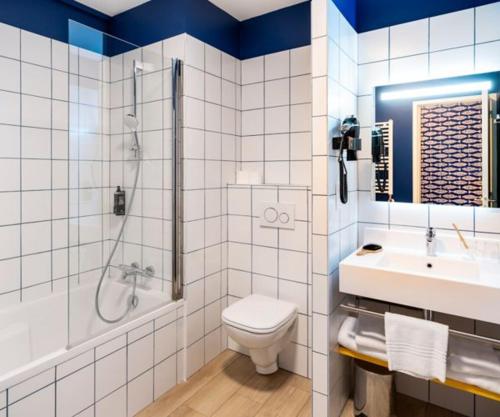 a bathroom with a toilet and a shower and a sink at ibis Styles Morlaix in Morlaix