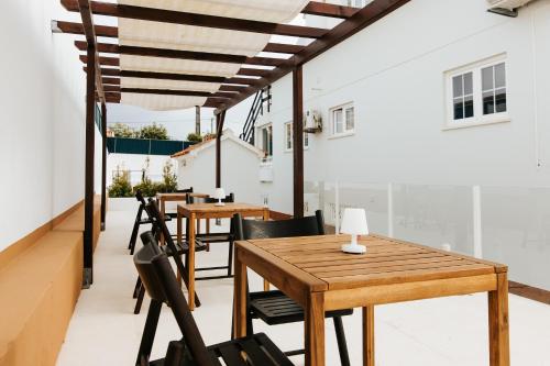 a row of tables and chairs on the roof of a building at Boutique Hotel - O House Ericeira Hills in Ericeira